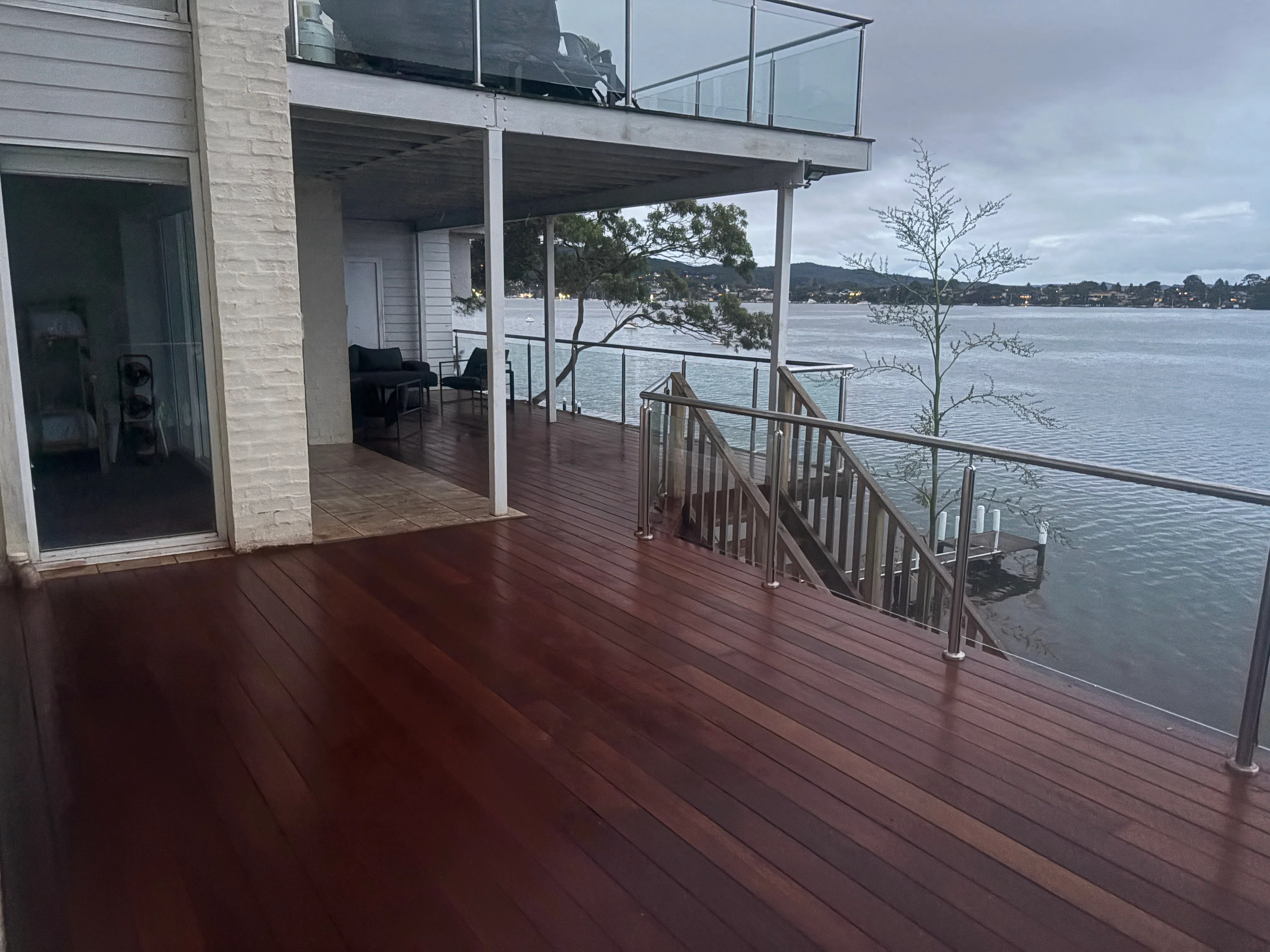 Merbau timber deck with a glass balustrade overlooking the water at Point Clare on the Central Coast