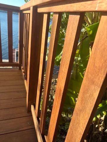 A custom merbau timber balustrade with vertical balusters on a waterfront deck